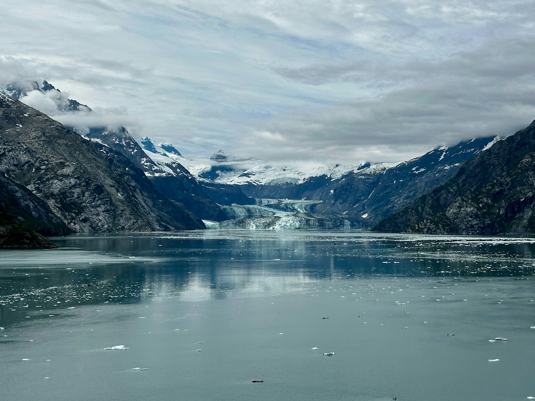 A wide Alaskan bay full of floating ice, with a glacier at the far end