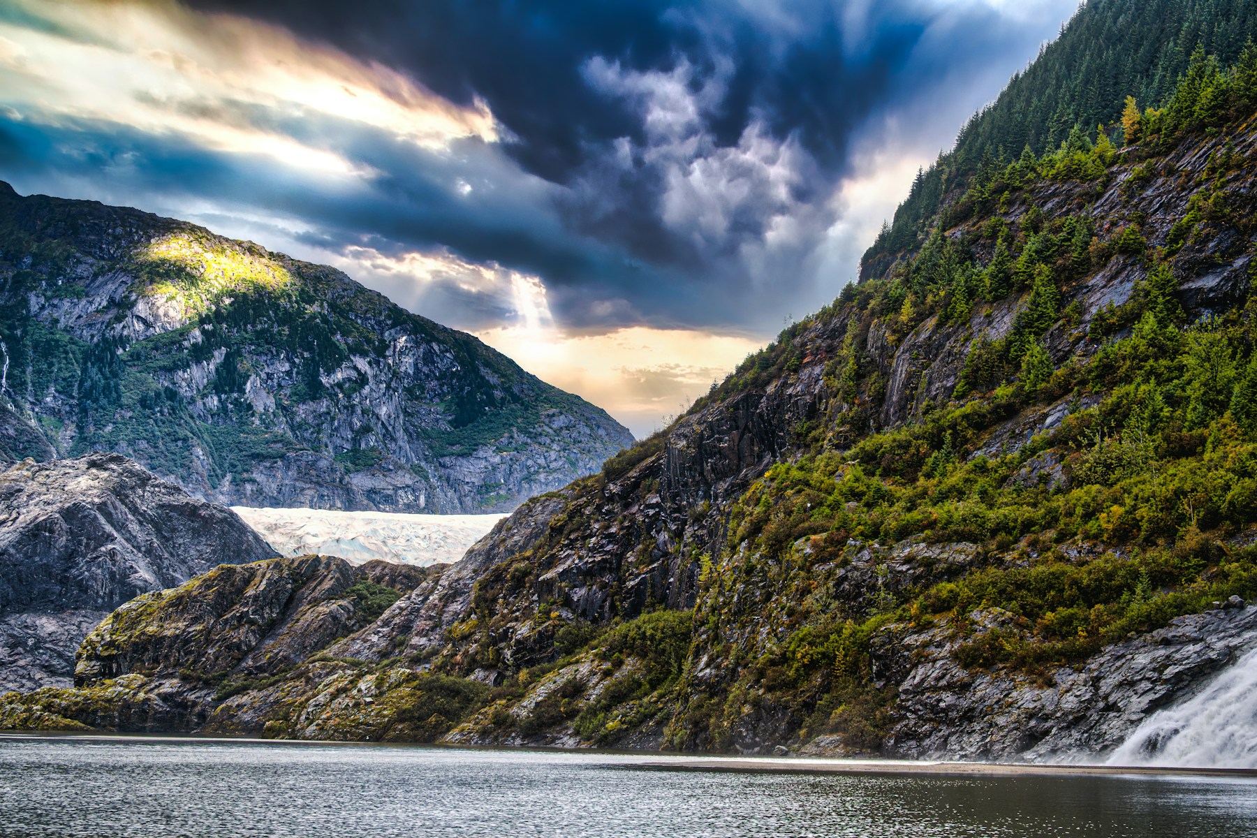 A steep green valley in Alaska with a glacier at the head of it